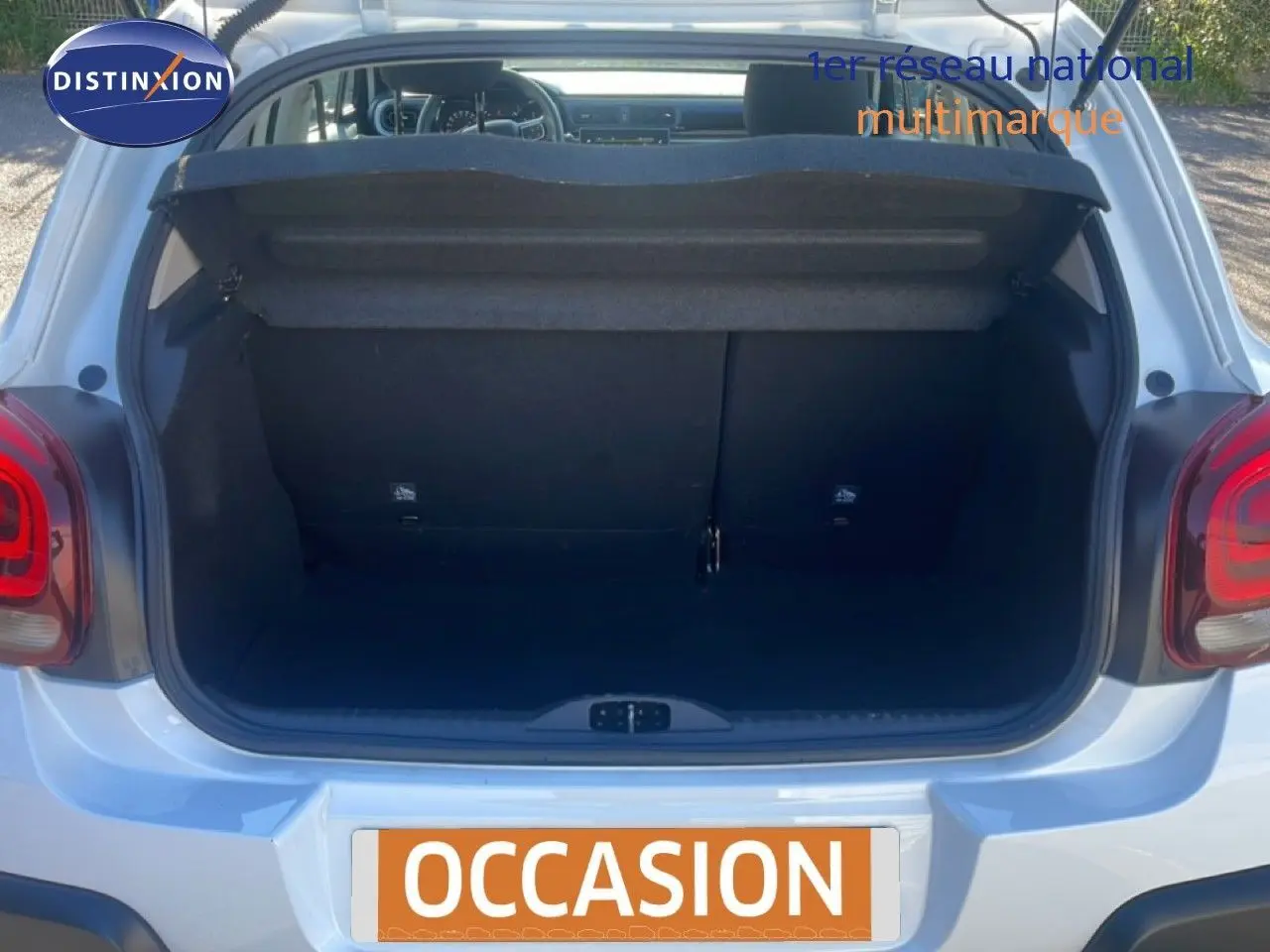 Coffre ouvert vu de l'arrière d'une Citroën C3 blanche Banquise, montrant l'espace de chargement vide.