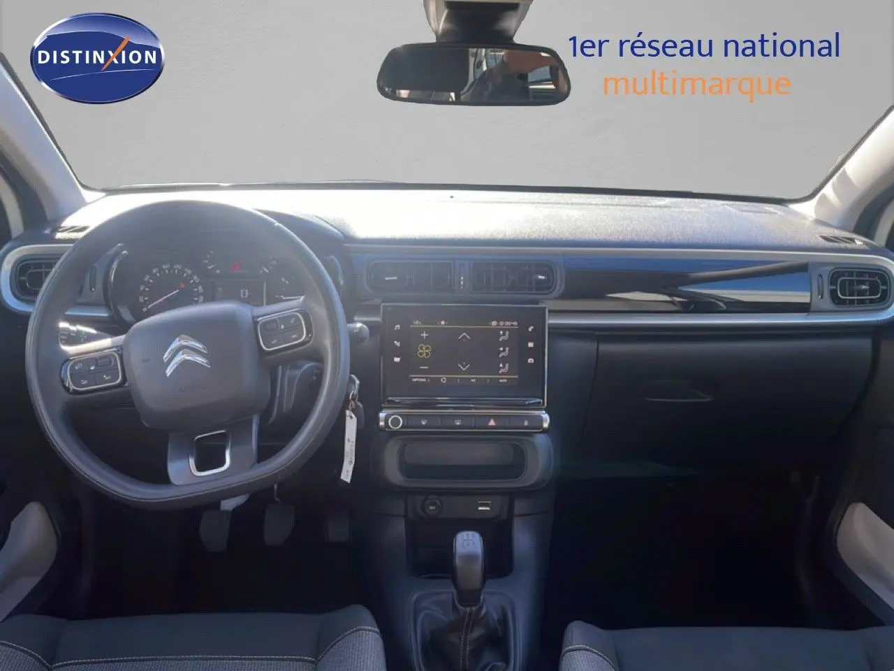 Intérieur de la Citroën C3 2020 en vue frontale, tableau de bord noir avec écran tactile et volant multifonction.
