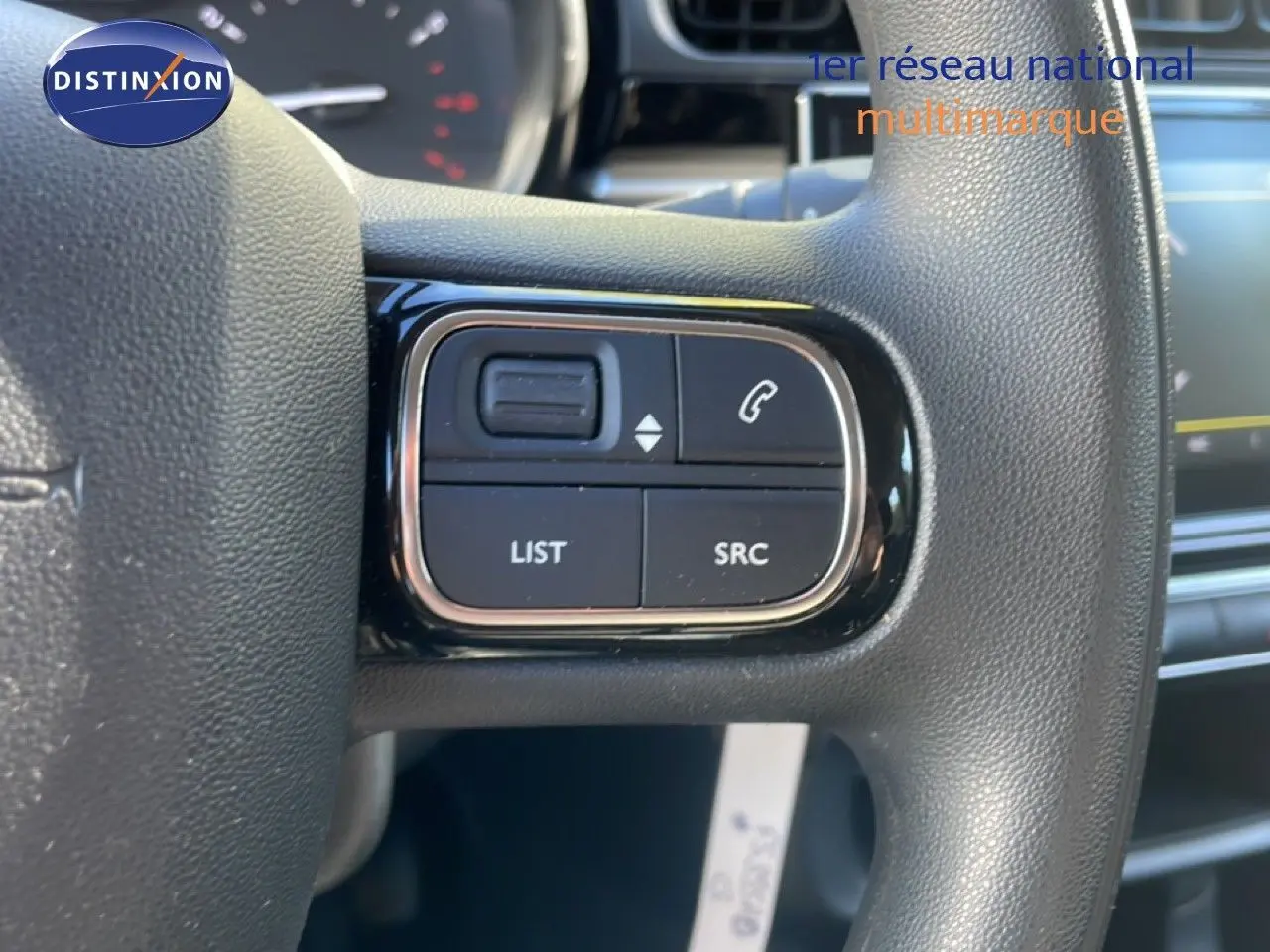 Gros plan sur les commandes au volant noir de la Citroën C3 1.5 BlueHDi 2020, côté gauche, avec boutons de gestion audio et téléphone.