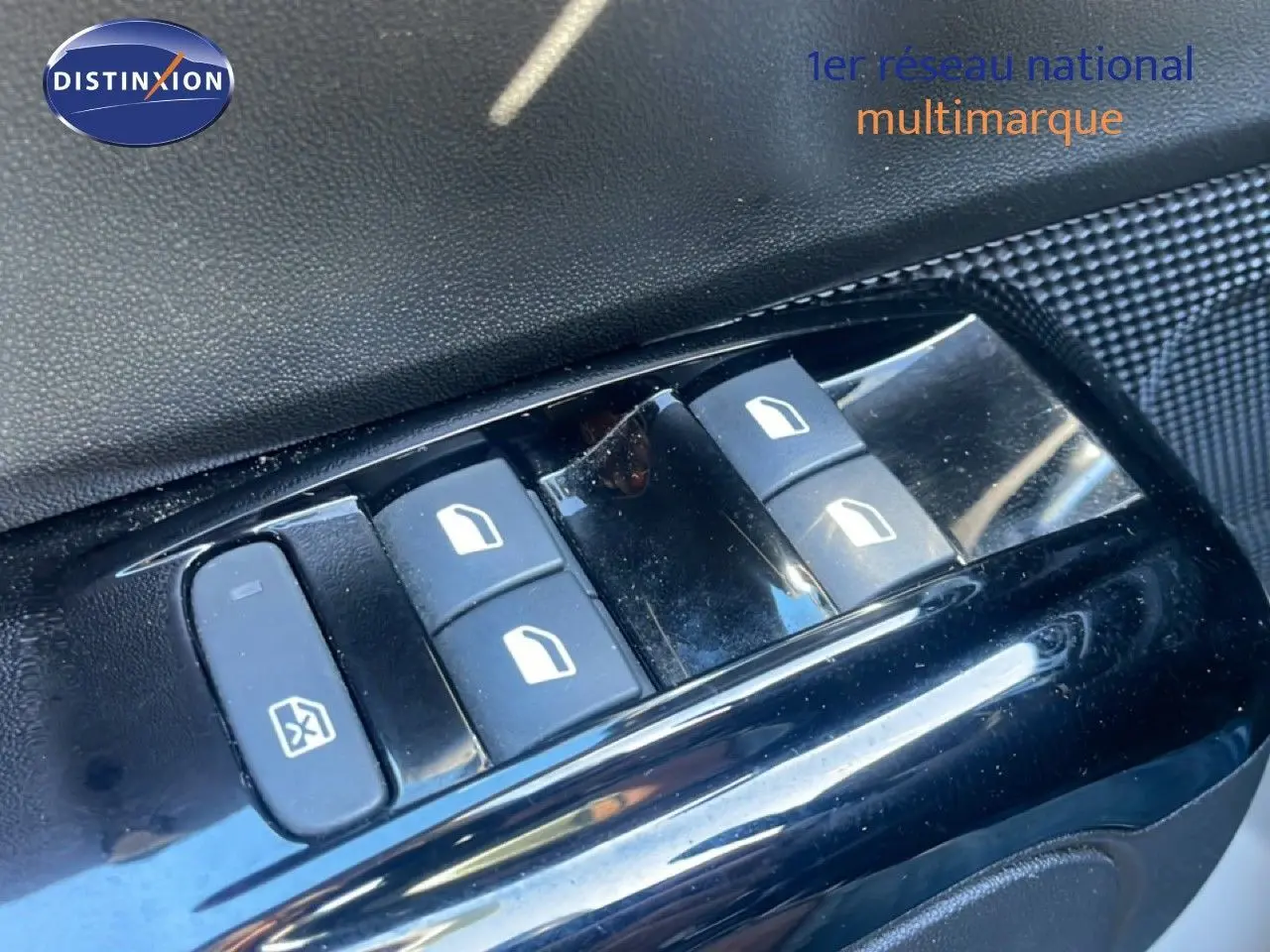 Gros plan sur les commandes de lève-vitres côté conducteur d'une Citroën C3 blanche banquise de 2020.