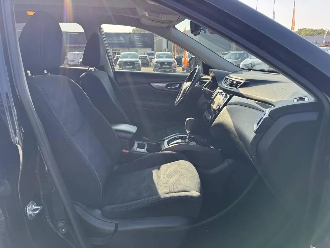 Intérieur noir du Nissan X-TRAIL 2017 vu côté conducteur, mettant en valeur les sièges et la console centrale.