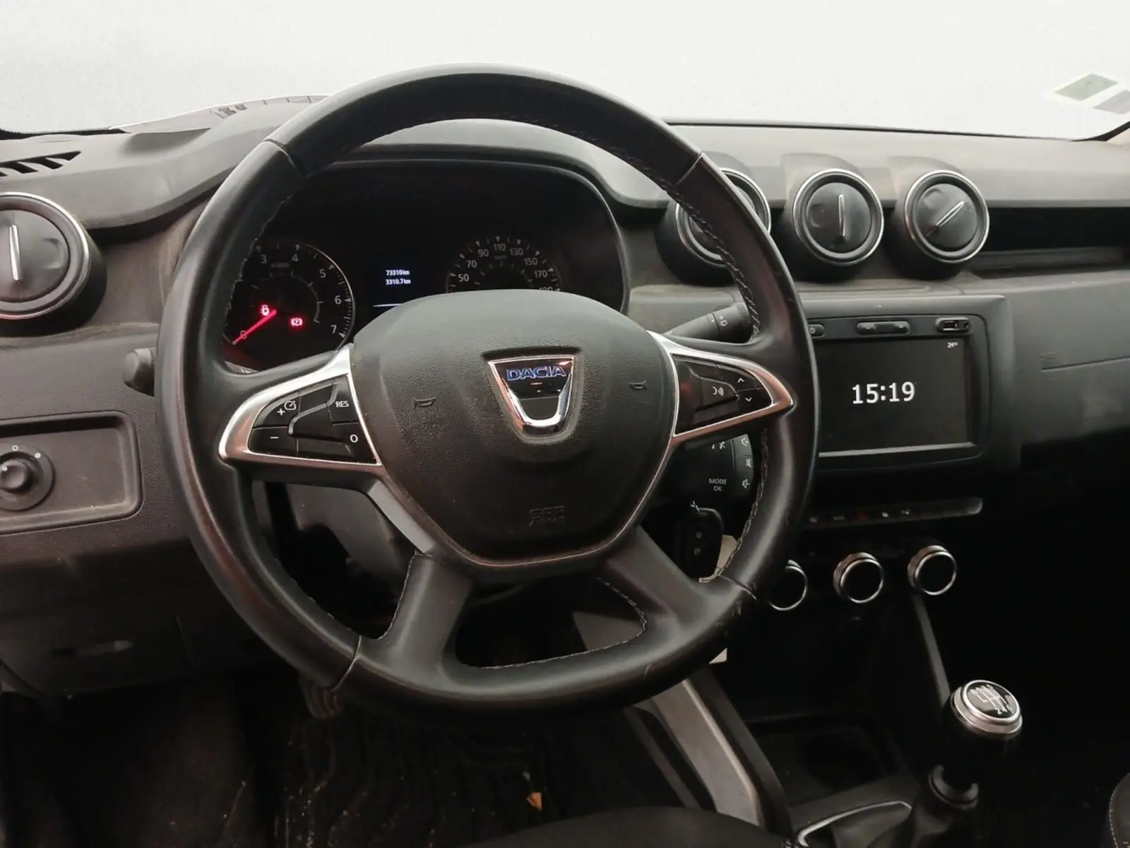 Vue intérieure côté droit des sièges arrière noirs du Dacia Duster 2021 blanc, avec ceintures de sécurité attachées.