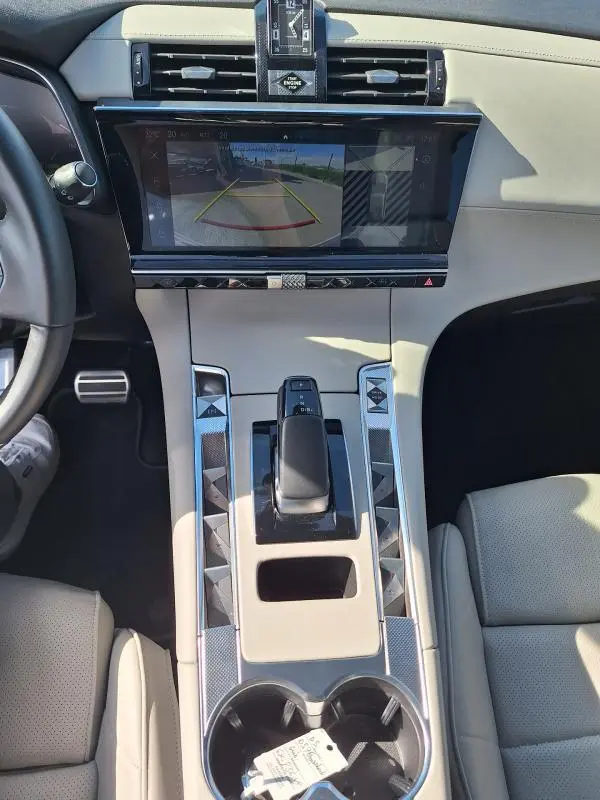 Vue intérieure centrée sur la console centrale beige du DS7 E-Tense 225 avec écran tactile affichant la caméra de recul.