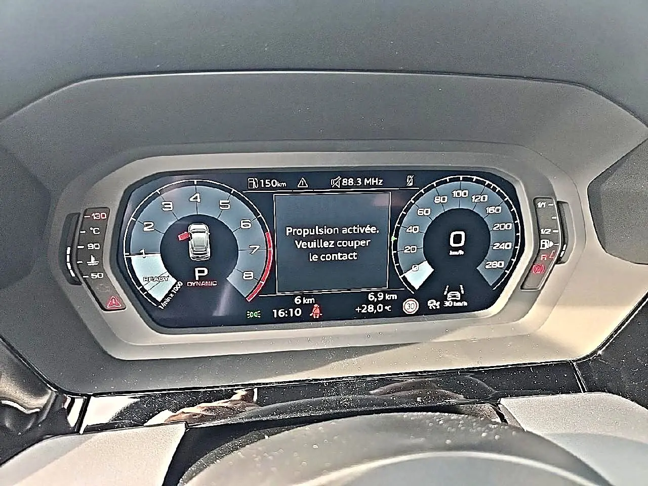 Tableau de bord numérique de l'Audi A3 Sportback 2026 affichant la vitesse et message d'arrêt moteur, vue de face.