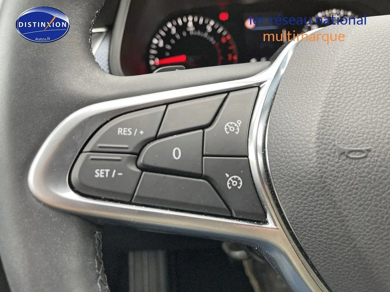 Gros plan sur les commandes de régulateur de vitesse au volant cuir noir du Renault Arkana 2023 finition Evolution.