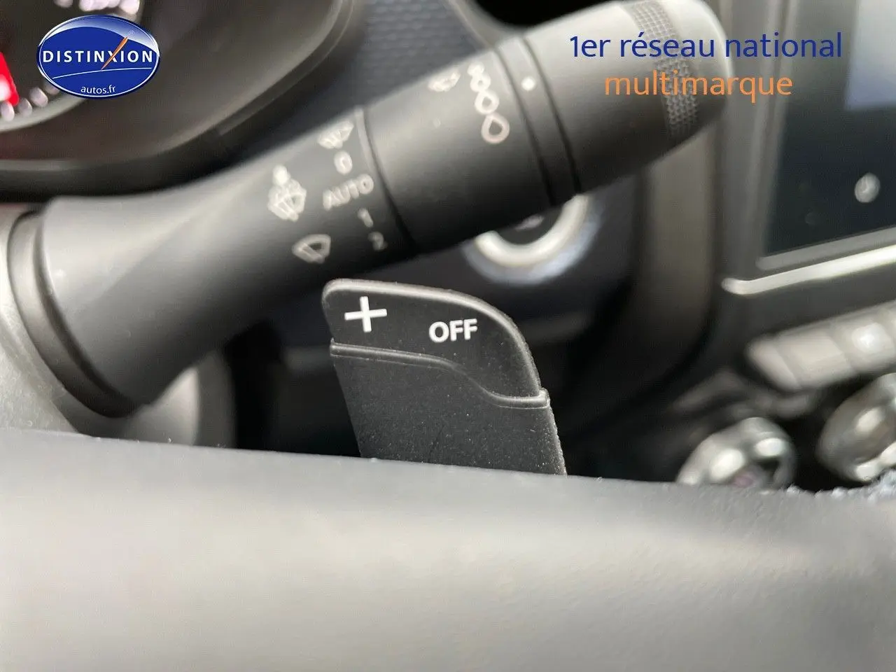 Gros plan sur la palette de changement de vitesse + OFF au volant d'un Renault Arkana noir métal, intérieur moderne.