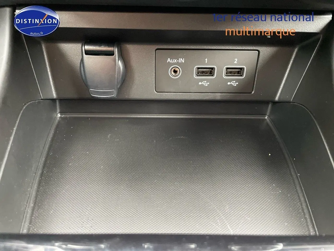 Gros plan sur la console centrale noire du Renault Arkana 2023 avec prises USB et entrée Aux-In visibles.