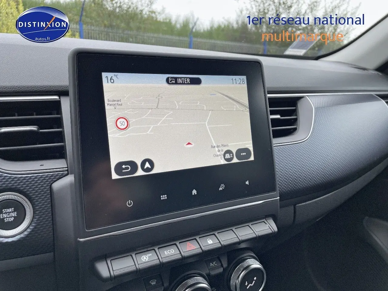 Écran tactile central avec navigation, tableau de bord et console d'une Renault Arkana noir métal vue de l'intérieur côté passager.