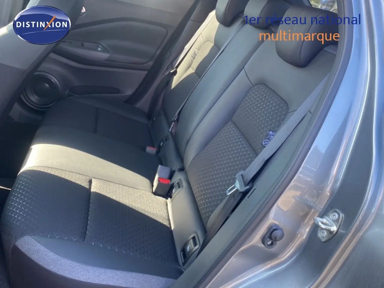 Vue côté droit des sièges arrière noirs avec tissu texturé dans un Nissan Juke gris squale métal toit noir 2025.