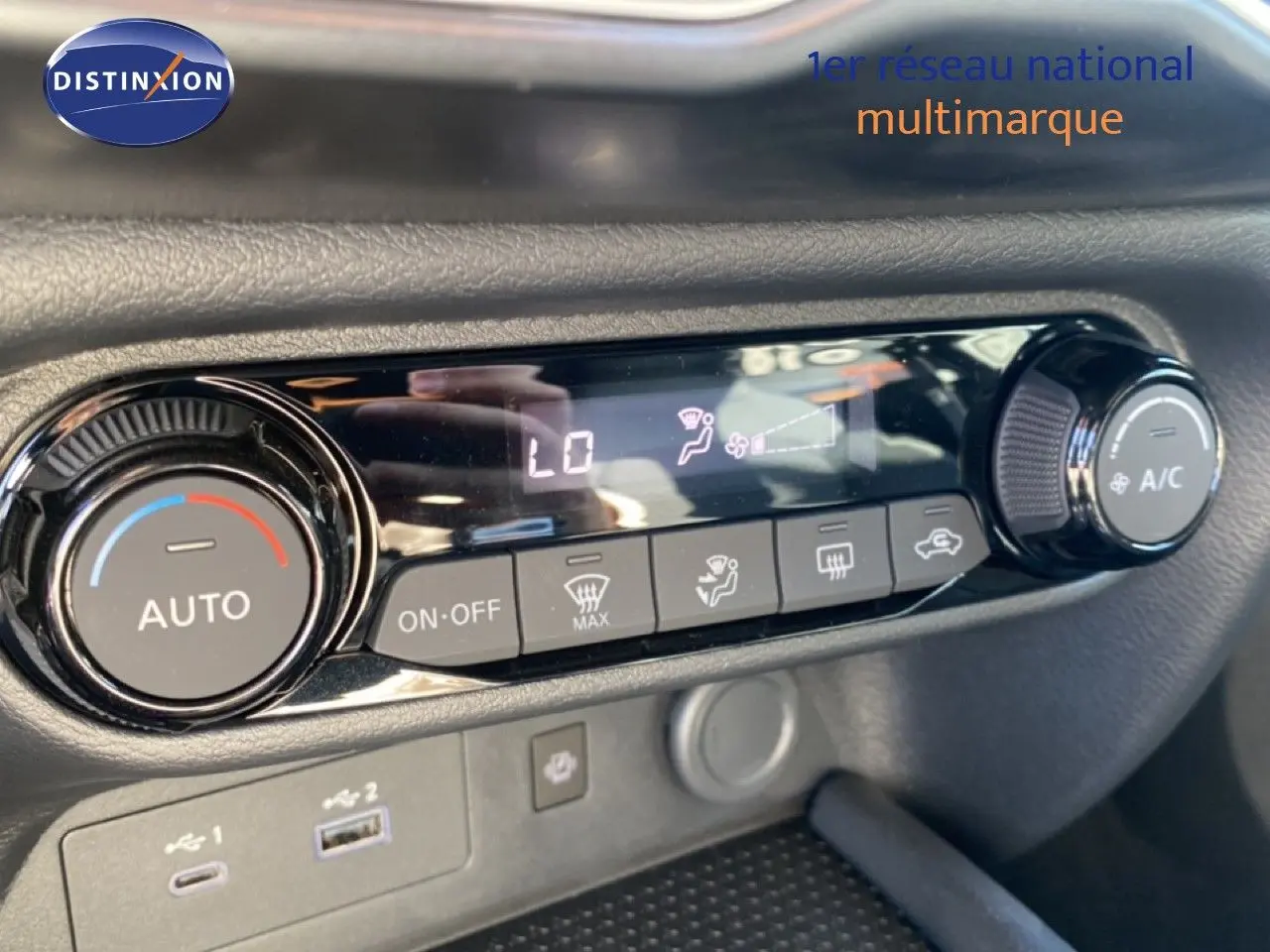Gros plan sur la commande de climatisation automatique du Nissan Juke gris squale métal avec toit noir, affichage digital et boutons tactiles.
