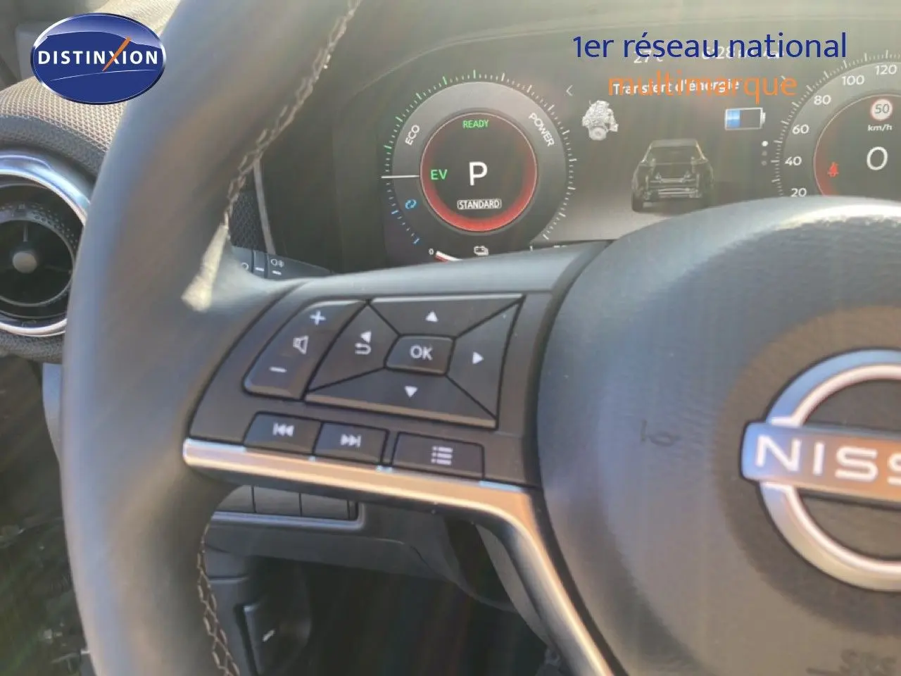 Gros plan sur le volant et le tableau de bord numérique du Nissan Juke 2025, avec commandes intégrées et affichage hybride.