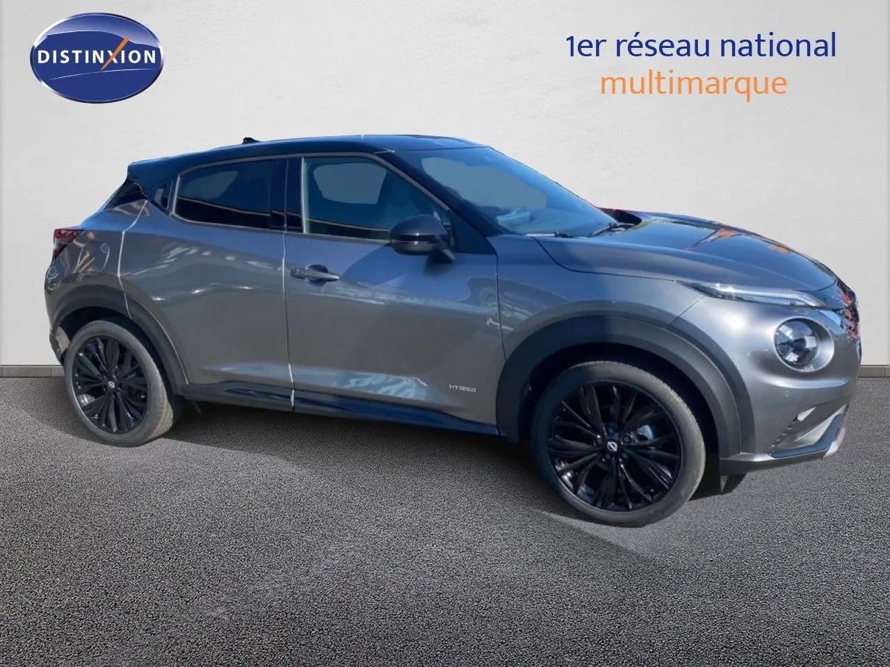 Vue de profil droit du Nissan Juke 2025 gris squale métal avec toit noir et jantes noires sport.