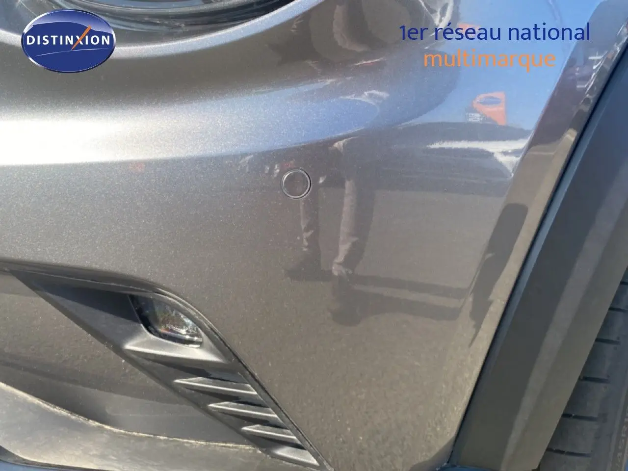 Gros plan sur l'avant droit gris squale métal du Nissan Juke 2025, mettant en valeur le pare-chocs et antibrouillard.