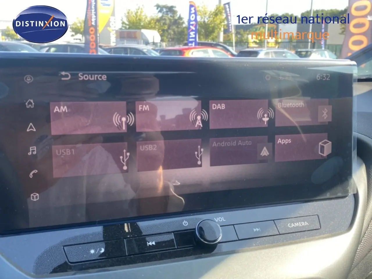 Vue rapprochée de l’écran tactile multimédia du Nissan Juke 2025 gris squale métal avec toit noir, affichant les sources audio.