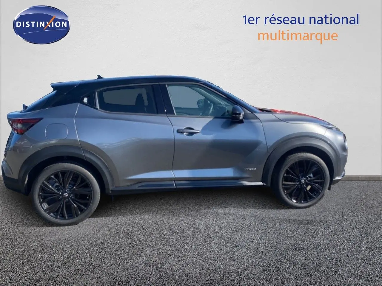 Profil droit du Nissan Juke 1.6 Full Hybrid gris squale métal avec toit noir et jantes noires, vue latérale extérieure.