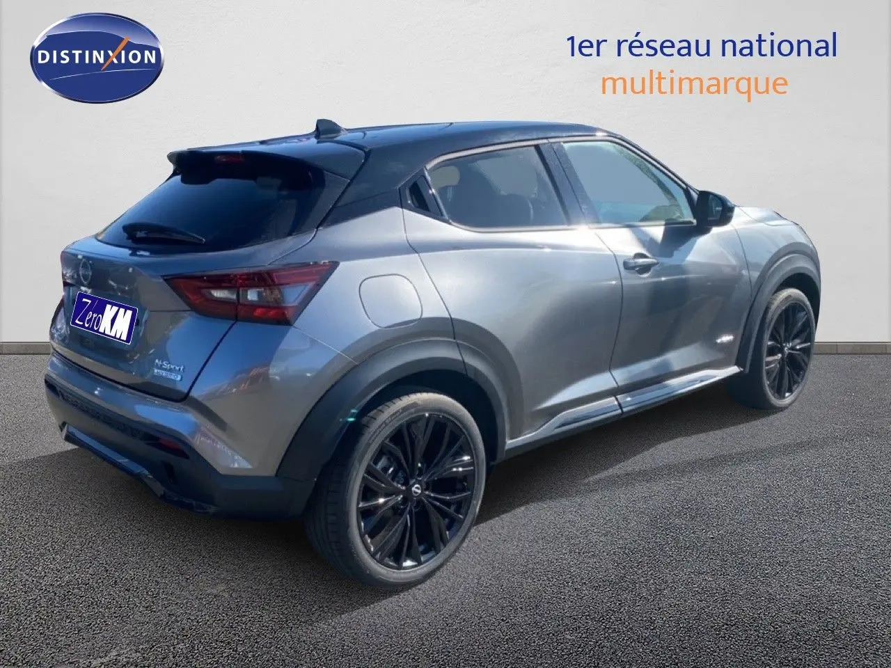 Vue 3/4 arrière droite du Nissan Juke 2025 gris squale métal avec toit noir et jantes noires sport.