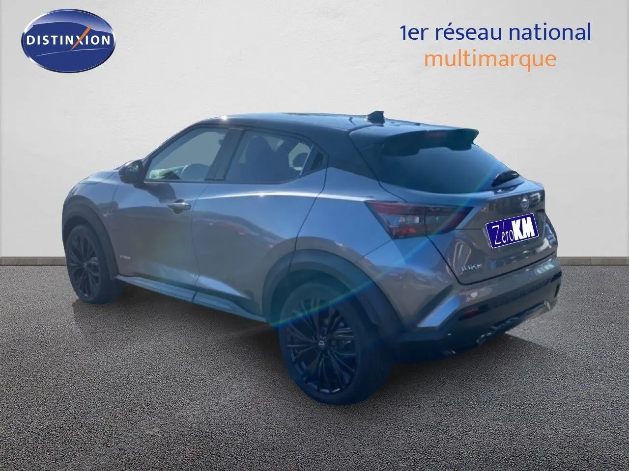 Nissan Juke 2025 gris squale métal avec toit noir, vue 3/4 arrière droit, jantes noires et lignes dynamiques.