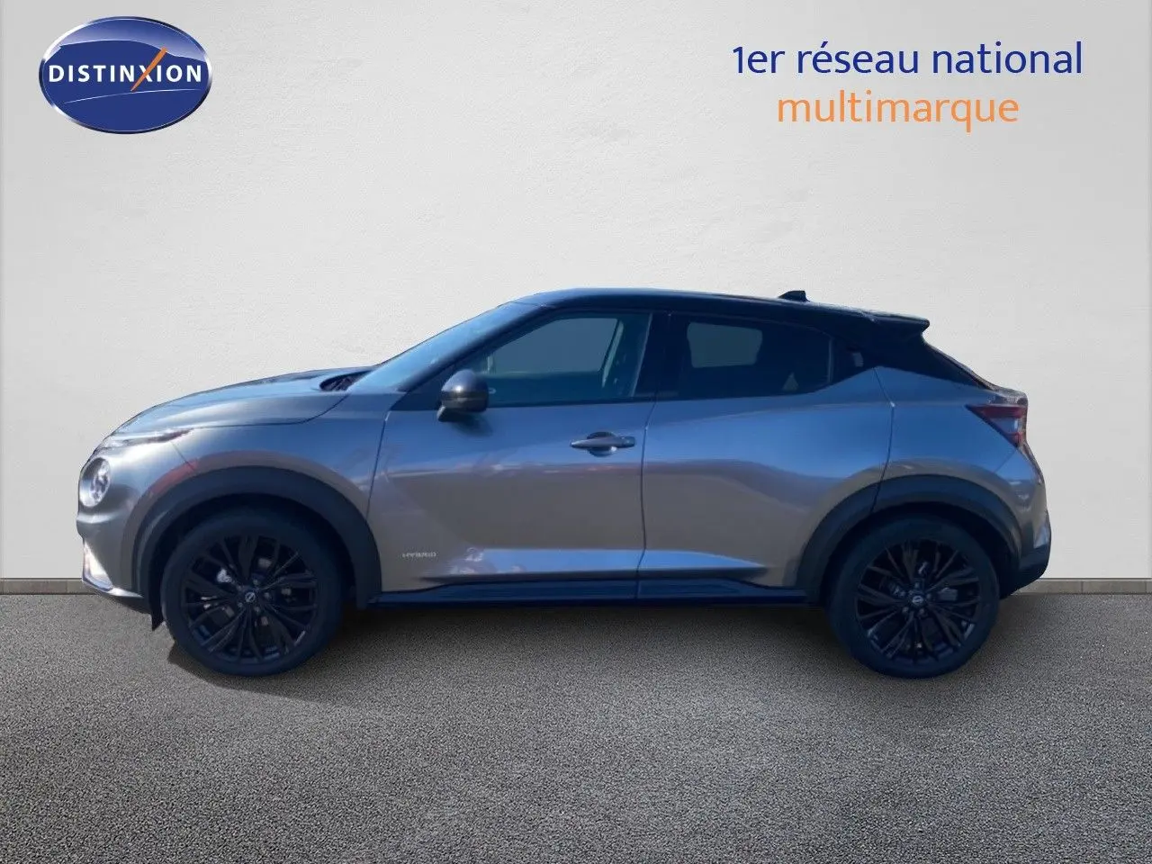 Vue latérale droite du Nissan Juke 1.6 Full Hybrid gris squale métal avec toit noir et jantes noires.