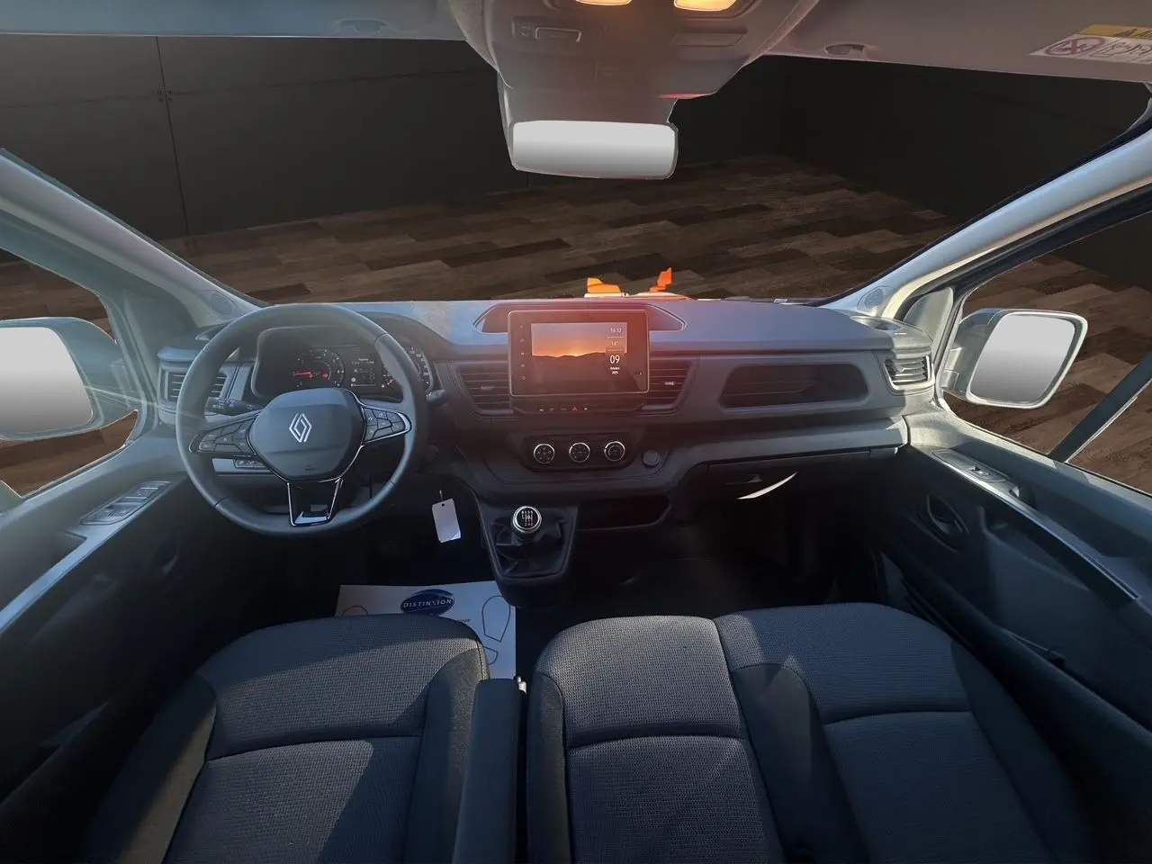 Intérieur avant du Renault Trafic Combi 2025 avec tableau de bord noir, volant multifonction et écran tactile central.