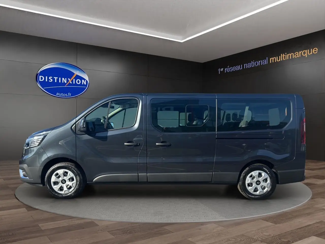 Profil latéral droit du Renault Trafic Combi gris comète 2025 avec portes coulissantes vitrées et jantes tôlées 16 pouces.