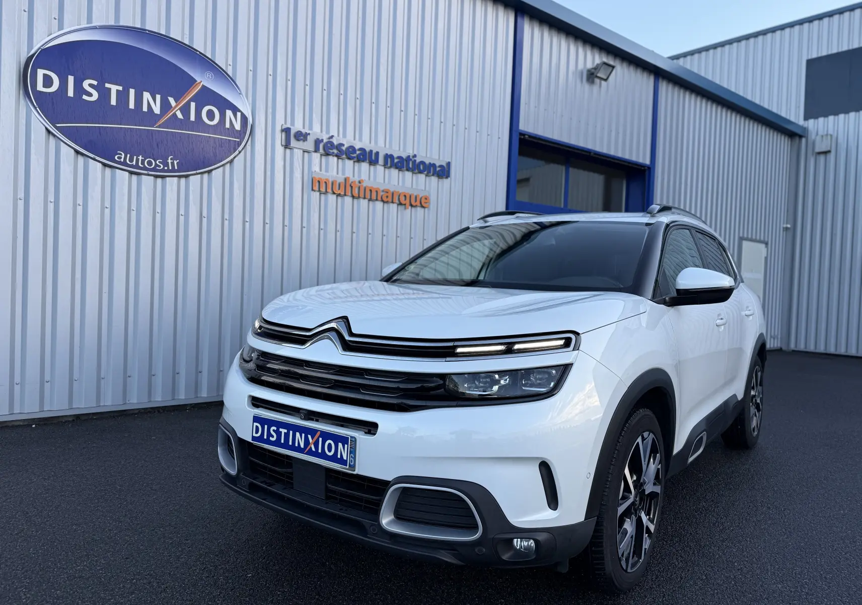 Citroën C5 Aircross blanc nacré en 3/4 avant droit, avec jantes bi-ton et signature lumineuse LED distinctive.