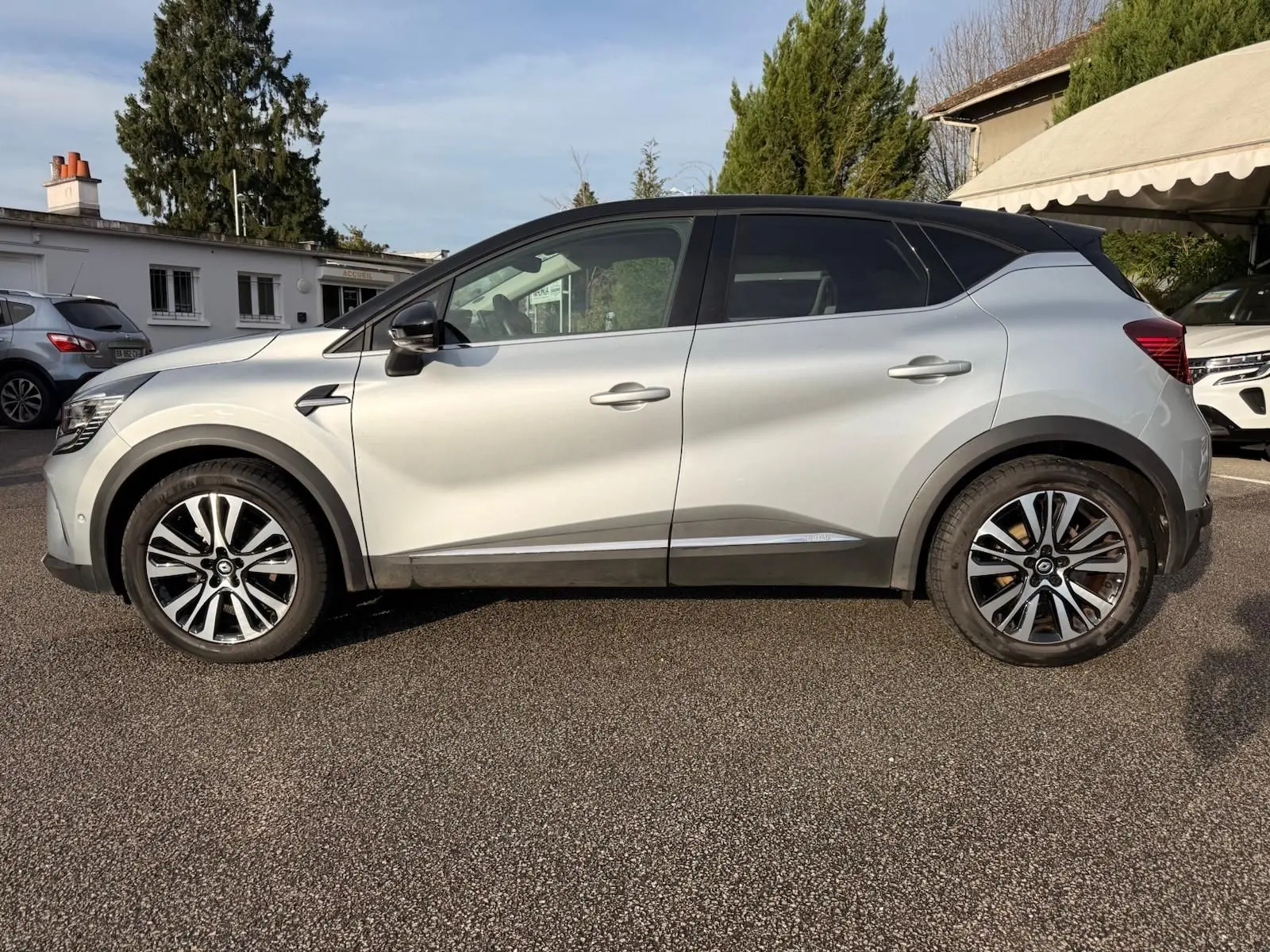 Profil latéral droit d'un Renault Captur gris Highland 2021 avec jantes alliage et toit noir contrasté.