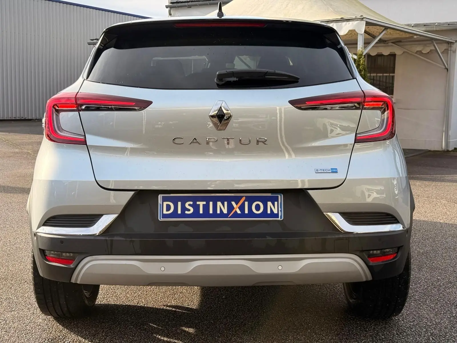 Vue arrière d'un Renault Captur gris Highland 2021 avec feux LED distinctifs et logo central brillant.