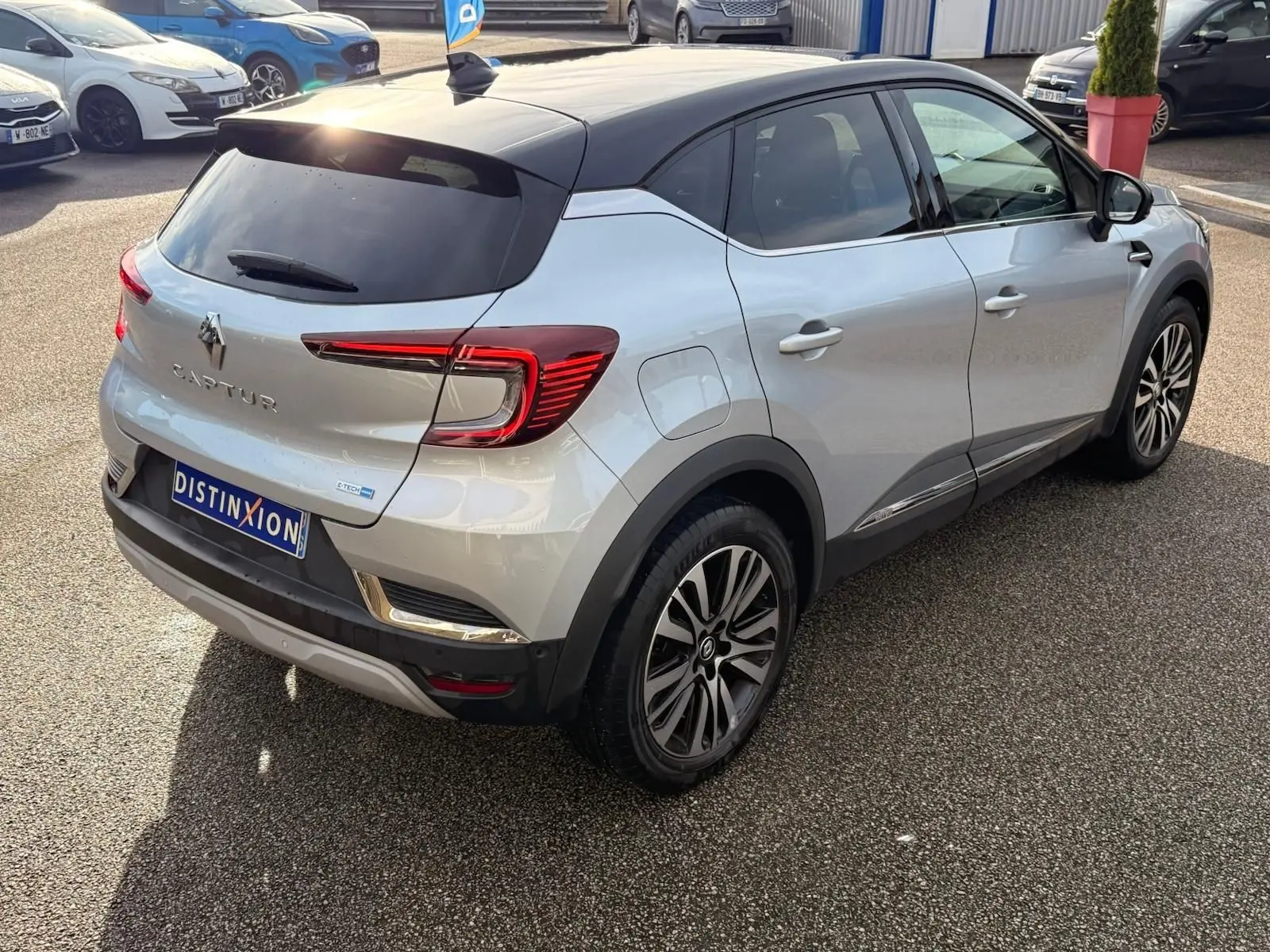 Vue 3/4 arrière droite du Renault Captur gris Highland avec toit noir et feux arrière LED distinctifs.