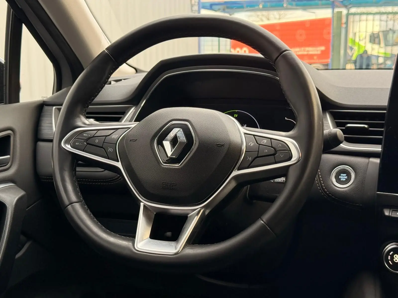 Vue rapprochée du volant cuir noir du Renault Captur 1.6 E-Tech hybride 2021 avec bouton démarrage visible.