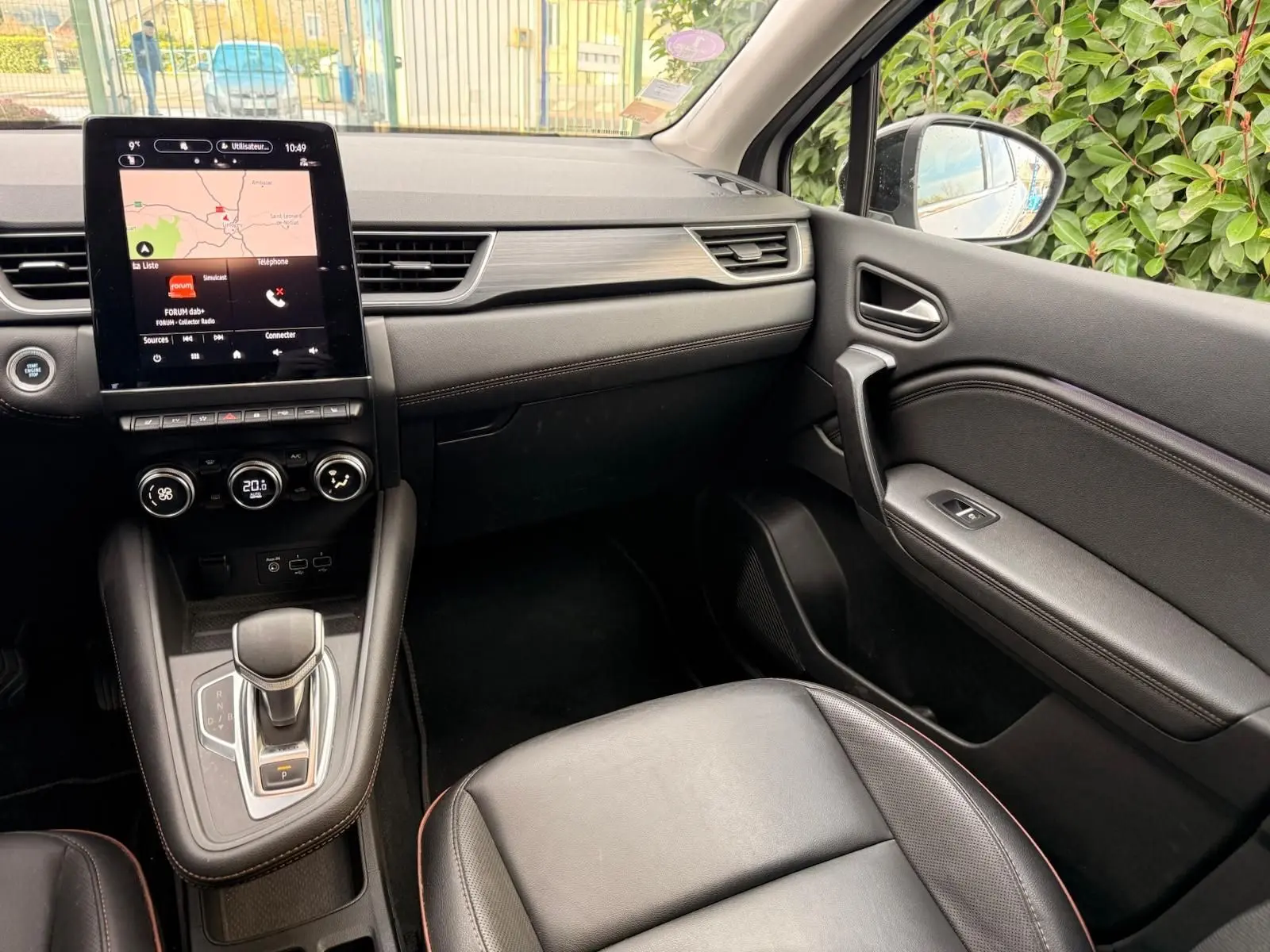 Intérieur du Renault Captur 1.6 E-TECH hybride 2021, vue côté passager avec console centrale et écran tactile noir.