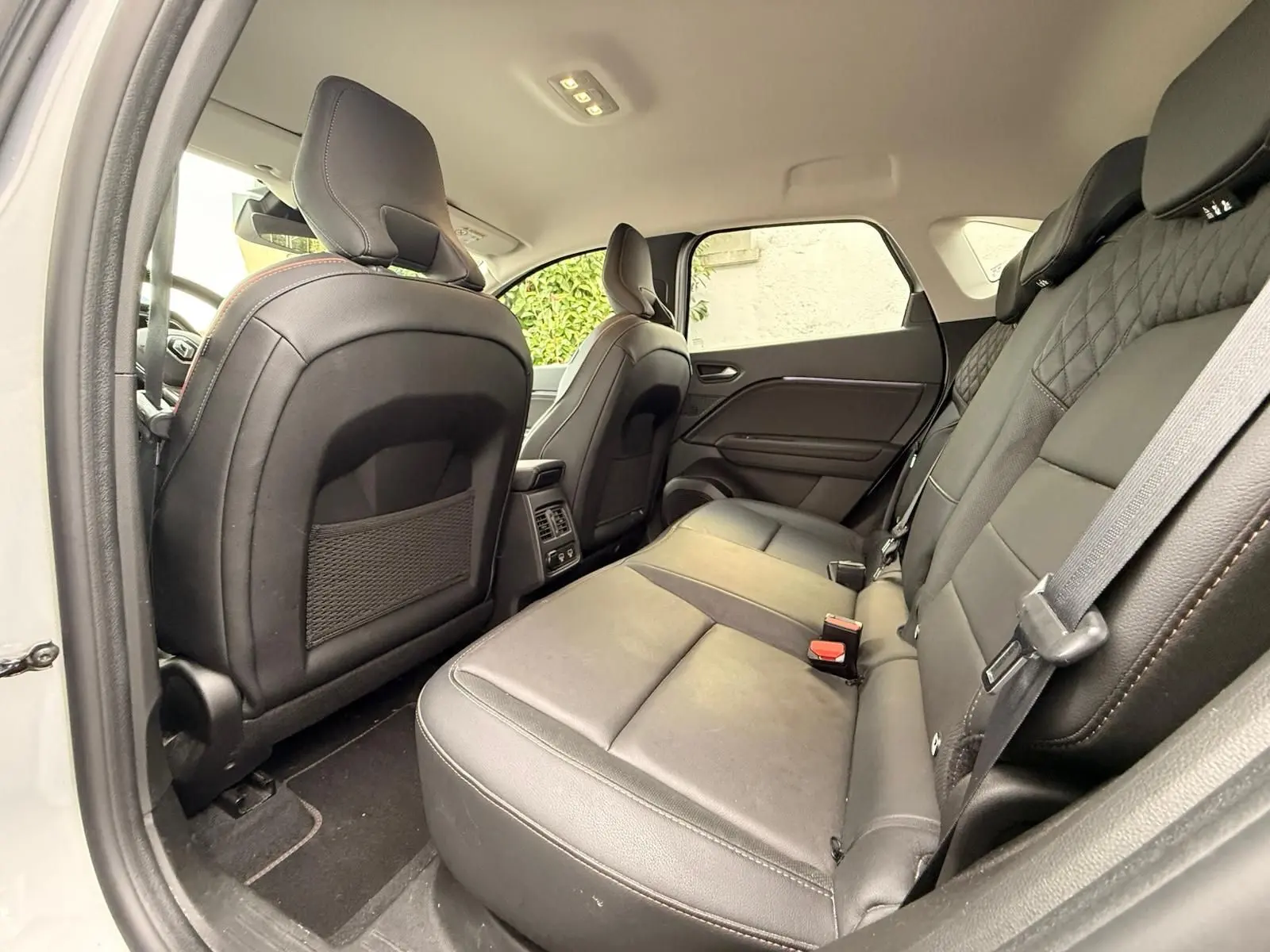 Vue intérieure arrière côté droit du Renault Captur 1.6 E-TECH Hybride 145ch Initiale Paris avec sièges cuir noirs.