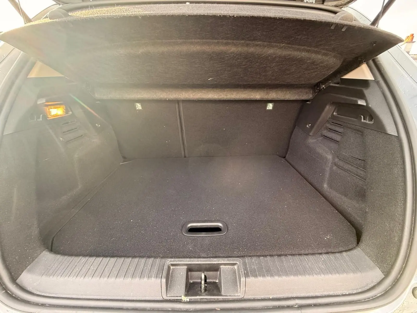 Coffre ouvert du Renault Captur gris Highland 2021, vue arrière montrant un espace de chargement propre et bien agencé.