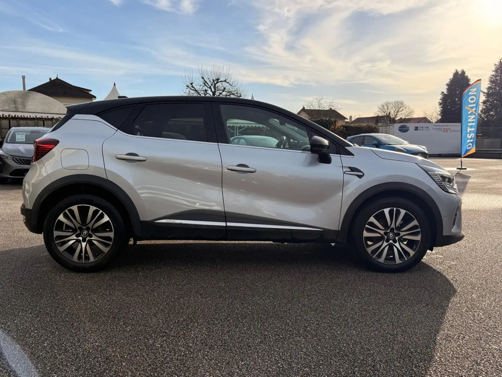 Profil côté gauche du Renault Captur gris Highland 2021 avec toit noir et jantes alliage distinctives.