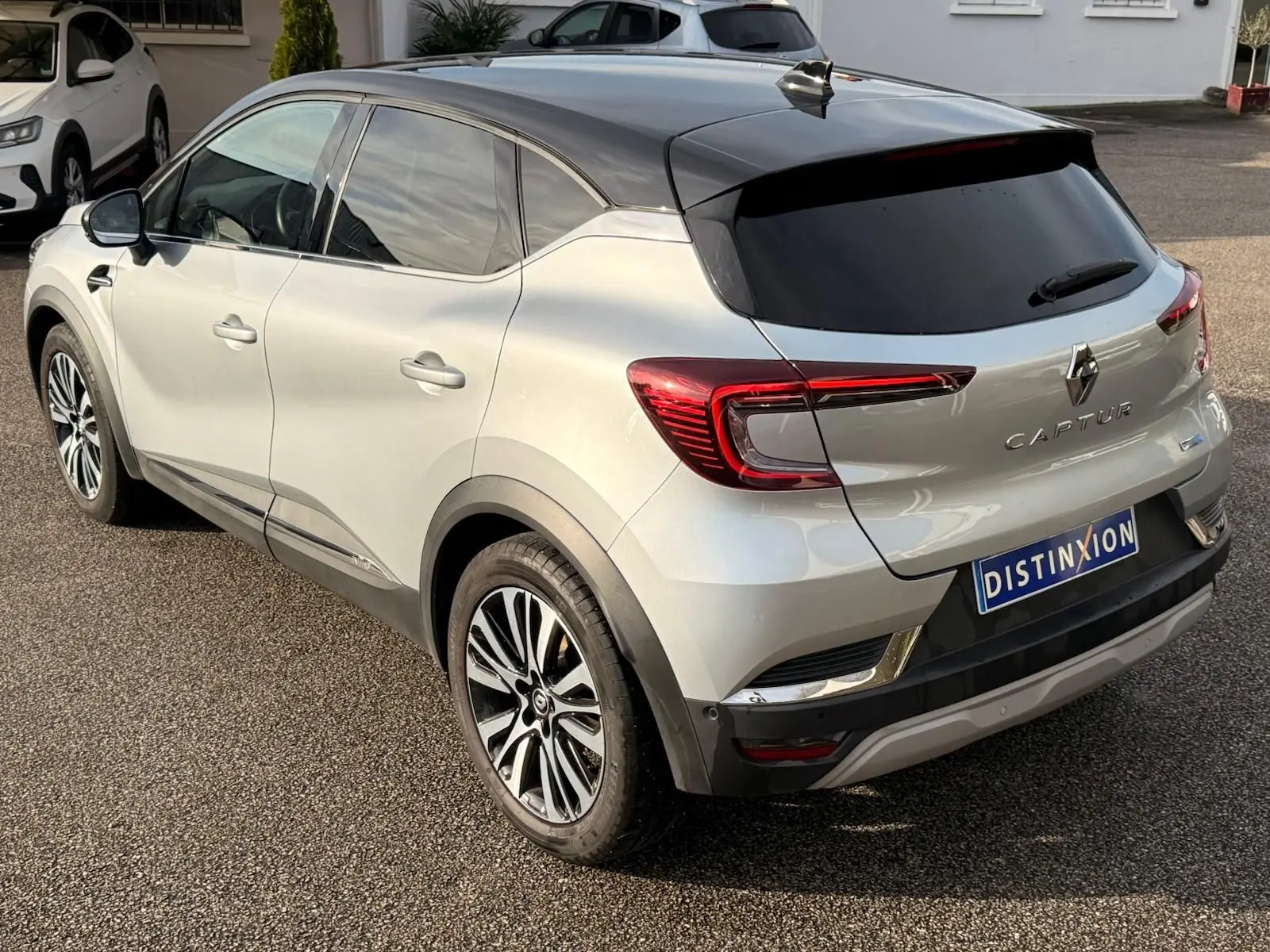 Vue 3/4 arrière droite du Renault Captur gris Highland avec toit noir et feux arrière LED distinctifs.