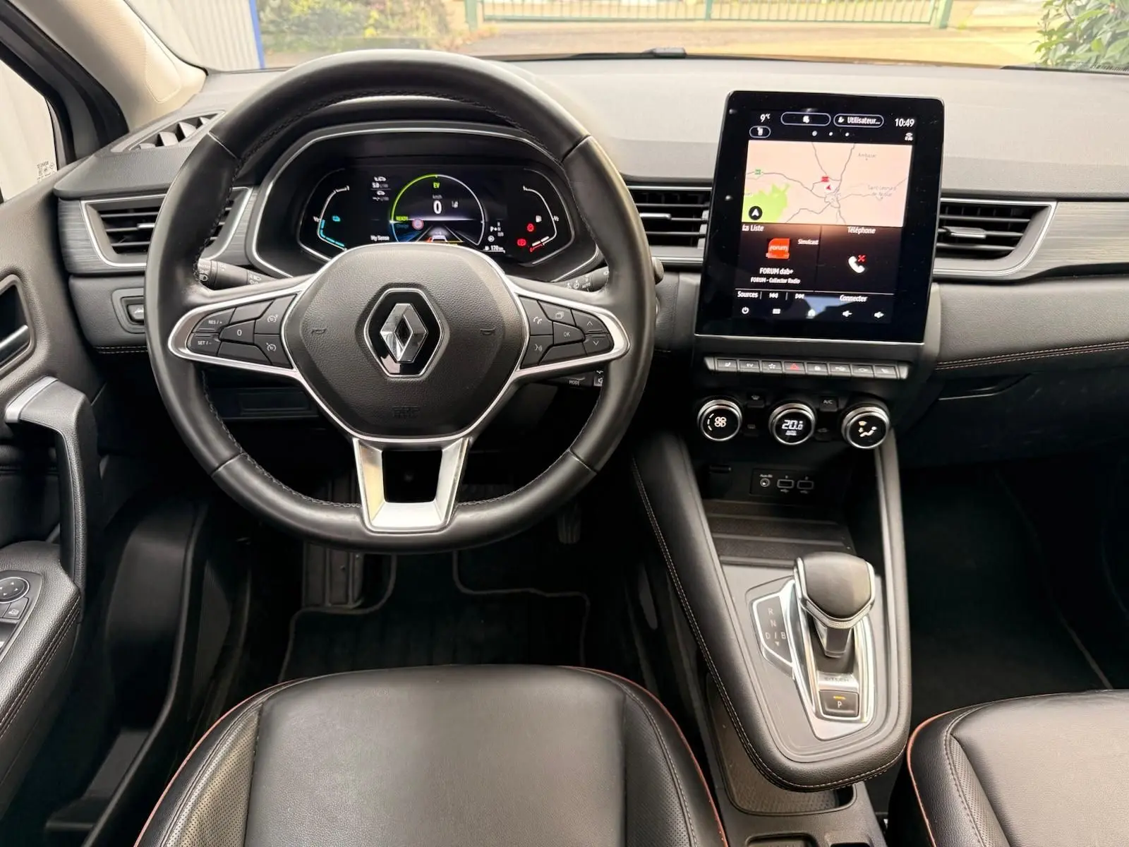 Intérieur Renault Captur 1.6 E-TECH hybride 2021, vue centrée sur le volant cuir et l'écran tactile avec navigation affichée.