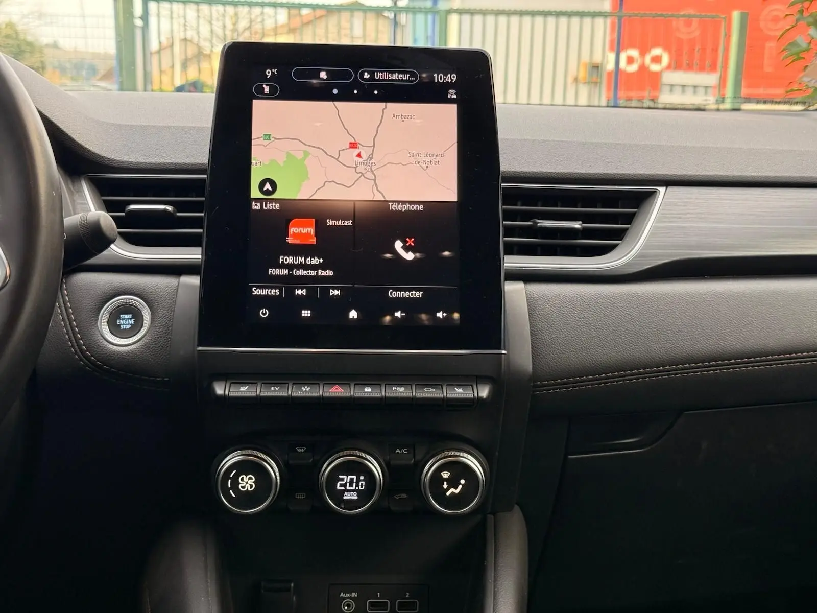 Vue centrale du tableau de bord du Renault Captur gris Highland 2021, avec écran tactile affichant la navigation et commandes climatiques.