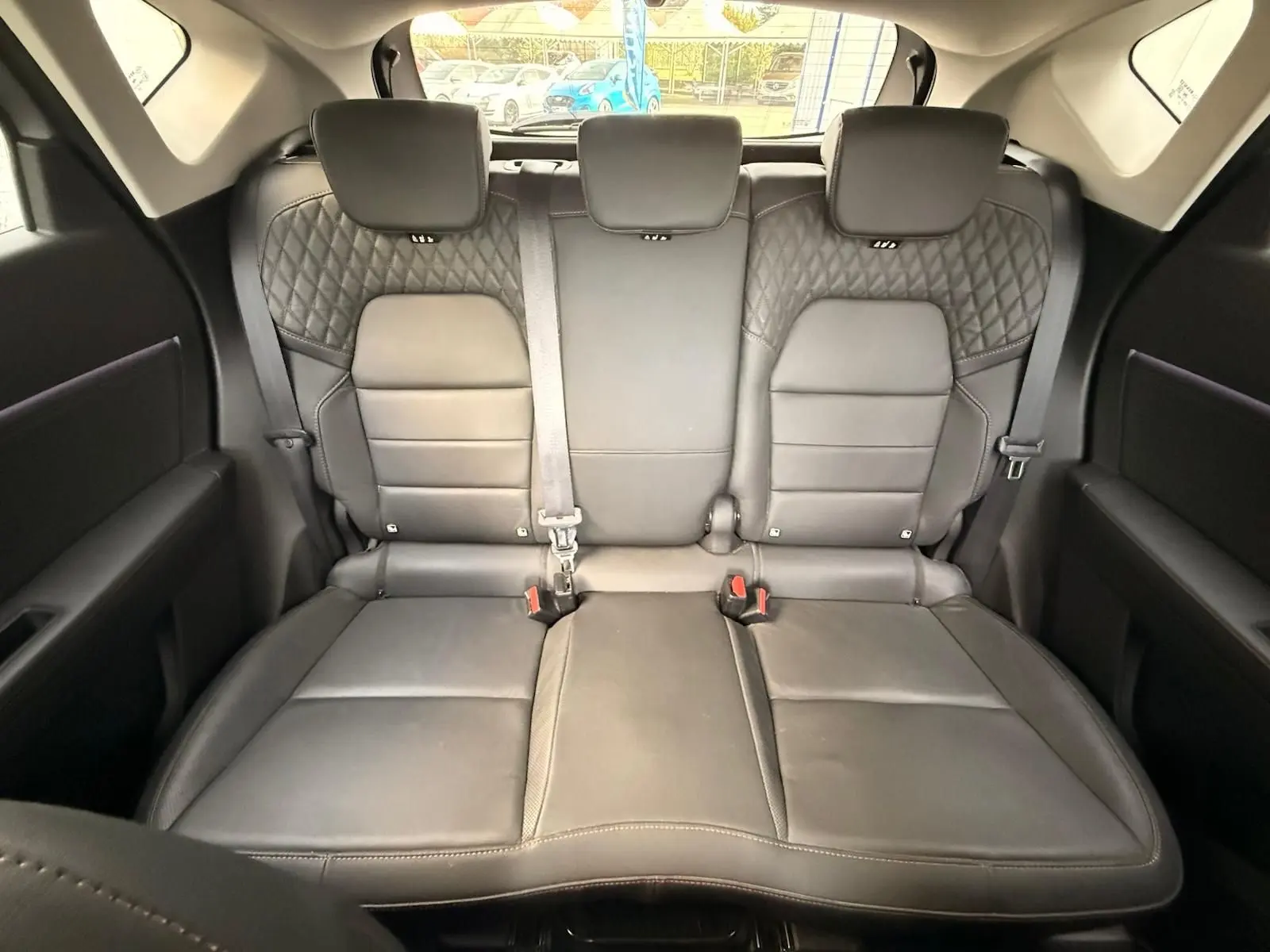 Vue arrière de l'intérieur du Renault Captur 2021, montrant la banquette arrière en cuir noir avec surpiqûres losangées.