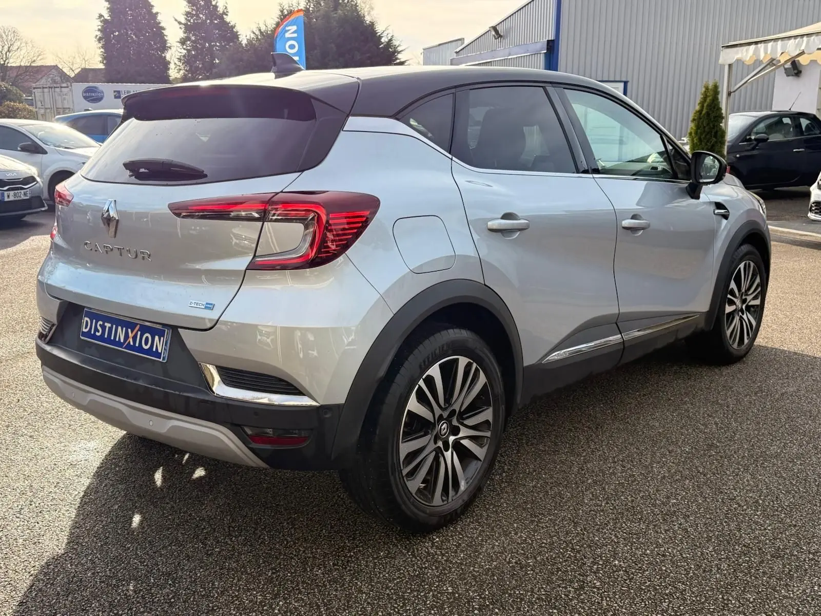 Vue 3/4 arrière droite d'un Renault Captur gris Highland avec toit noir et feux arrière LED distinctifs.