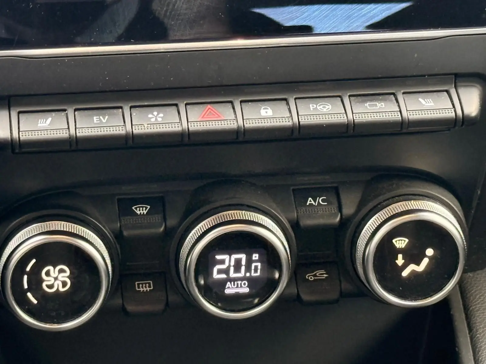 Gros plan sur la console de climatisation du Renault Captur gris Highland, affichant 20°C en mode automatique.