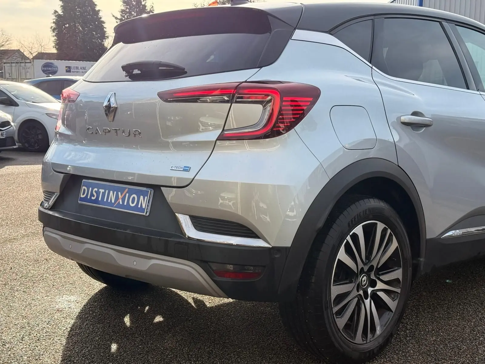 Vue 3/4 arrière droite d'un Renault Captur gris Highland avec feux LED et jantes alliage distinctives.