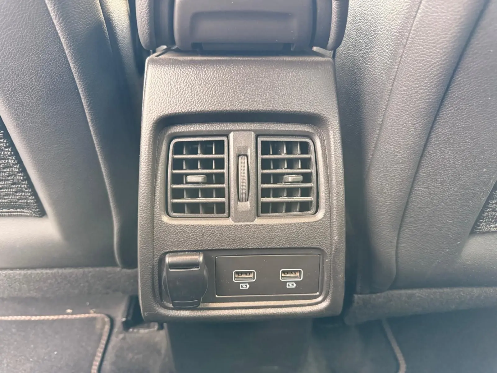 Prise USB double et sortie 12V sous les aérateurs arrière du Renault Captur gris Highland 2021, vue centrée depuis l'arrière.