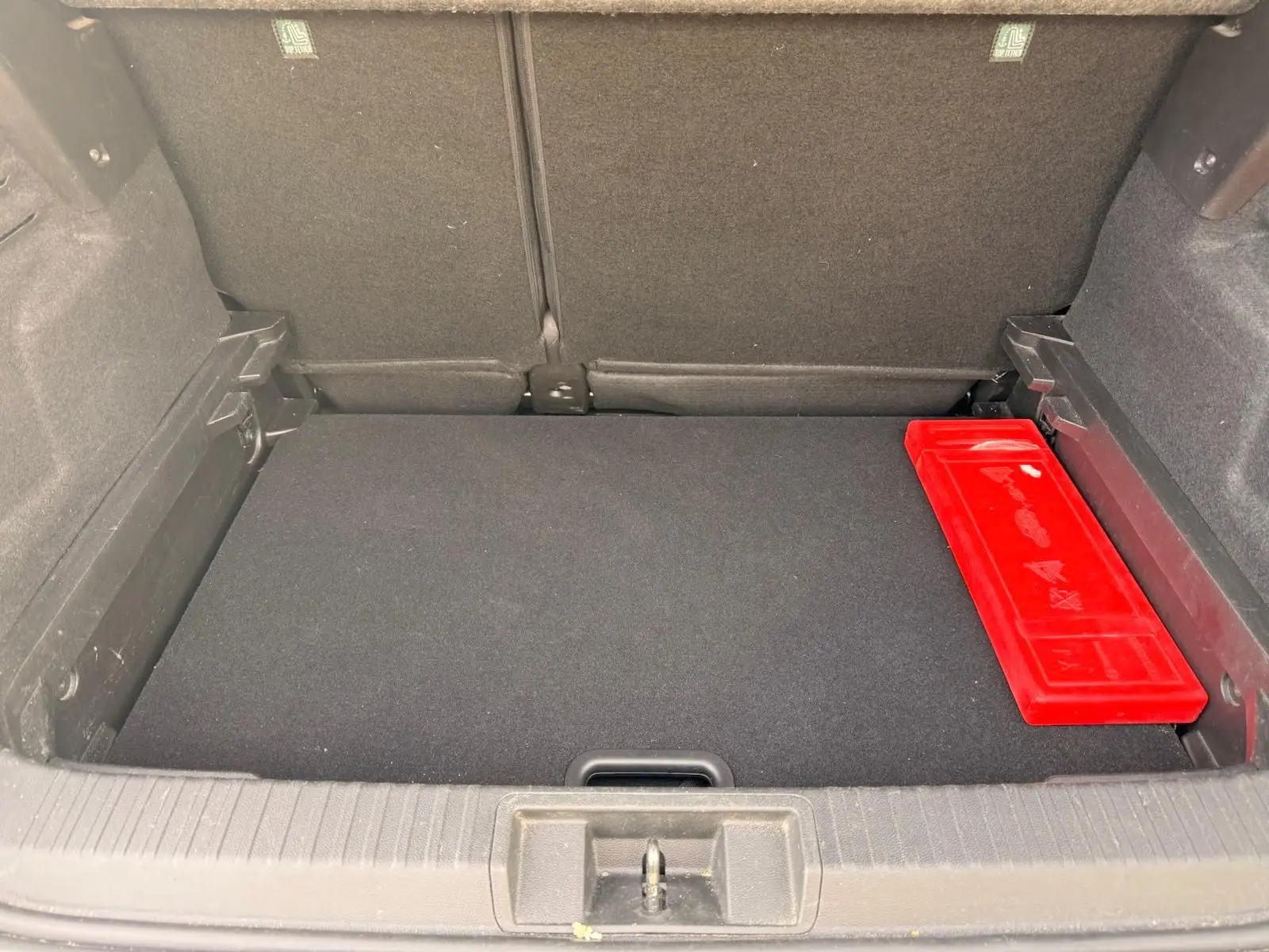 Coffre ouvert d’un Renault Captur gris Highland 2021, vue intérieure avec boîte à outils rouge à droite.