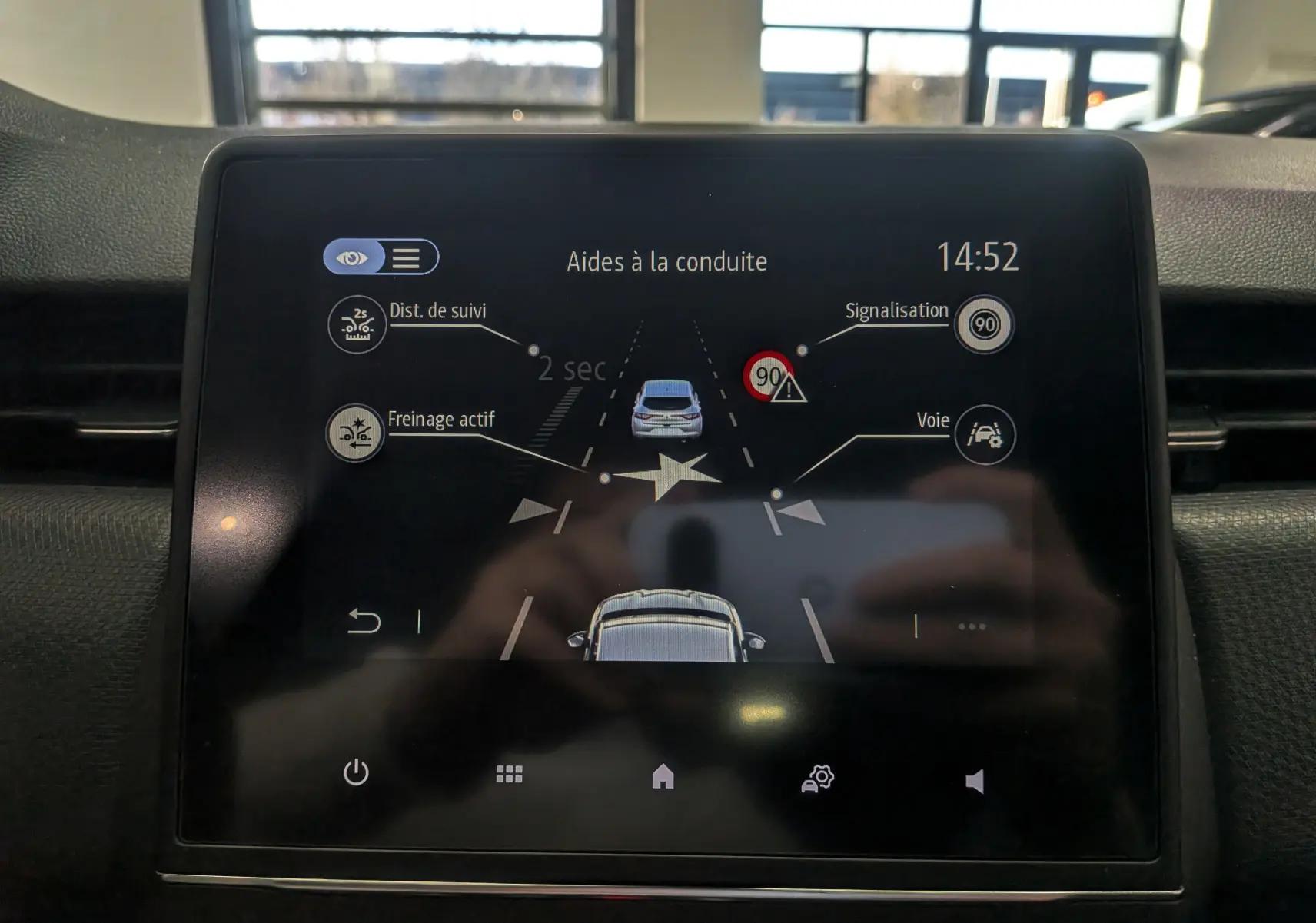 Écran tactile intérieur de la Renault Clio V blanc glacier montrant les aides à la conduite et alertes de sécurité.