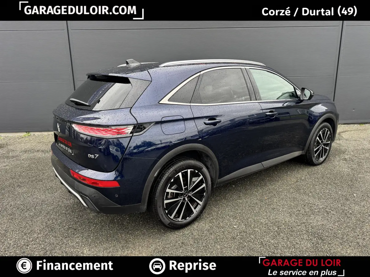DS7 Crossback bleu vue 3/4 arrière droit, jantes alliage noires et toit avec barres chromées.