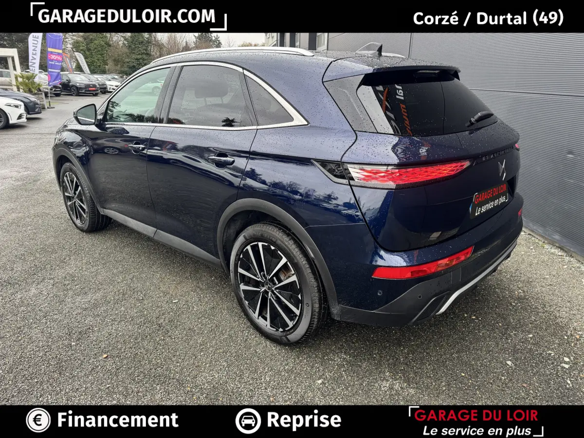 Vue 3/4 arrière droite d'un DS7 Crossback bleu 2024 avec feux arrière LED et jantes alliage noires.