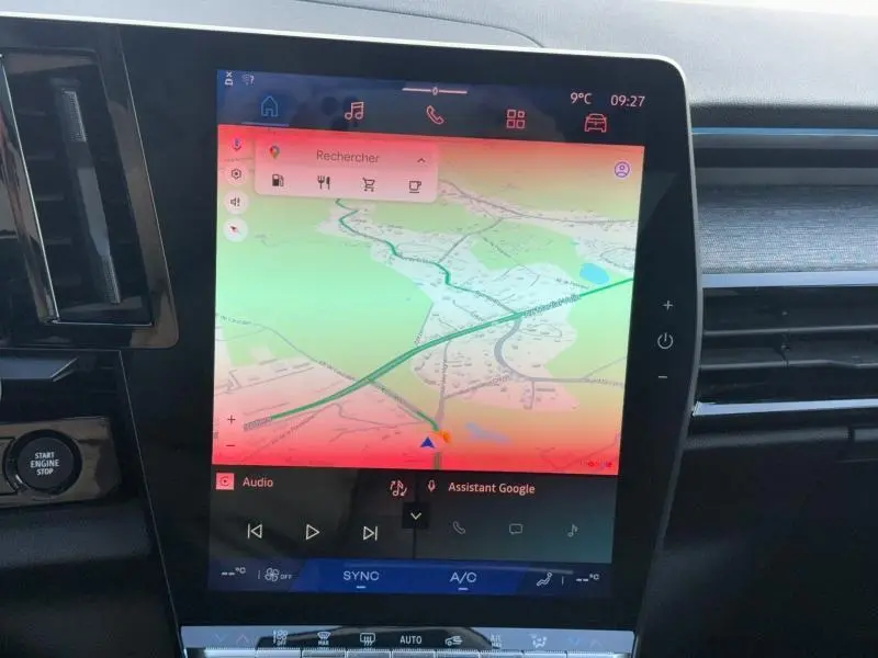 Écran tactile central du Renault Austral 2025 affichant la navigation, entouré de la console noire brillante et des aérateurs.