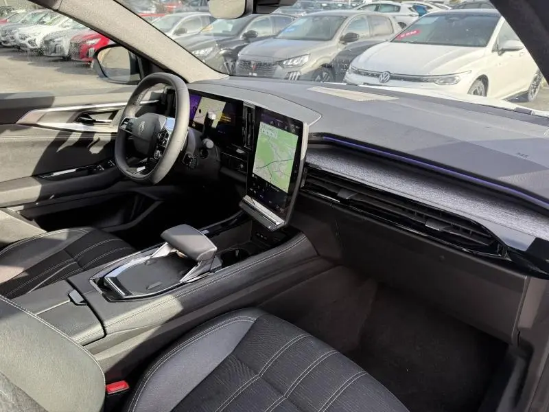 Vue intérieure côté conducteur du Renault Austral 2025, avec tableau de bord moderne et écran tactile vertical.