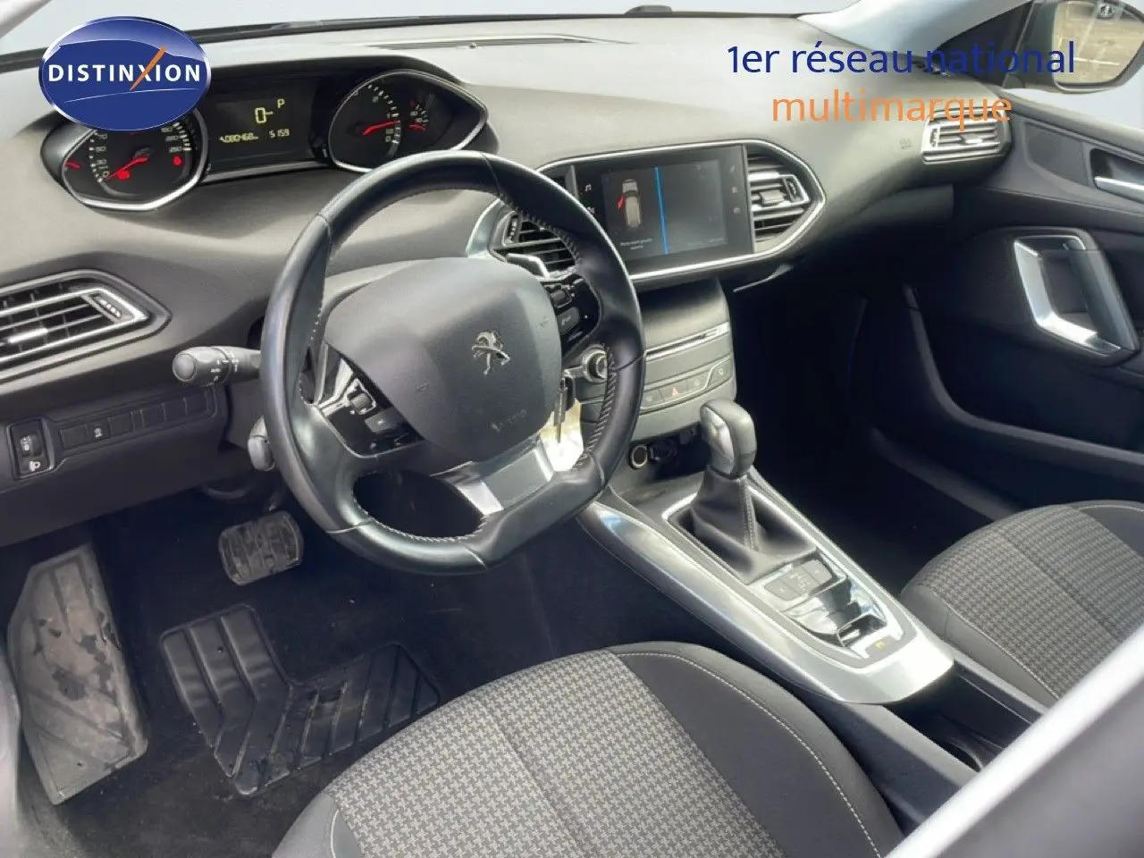Intérieur avant droit de la Peugeot 308 SW 2019 noir Perla Nera, volant cuir, tableau de bord avec écran tactile et boîte auto.