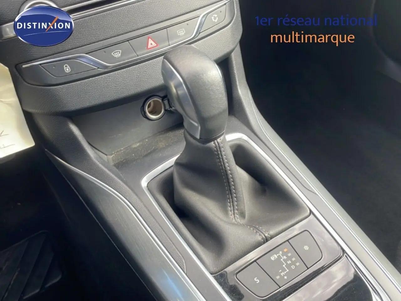Gros plan sur le levier de vitesses automatique de la Peugeot 308 SW noire, avec console centrale et commandes visibles.