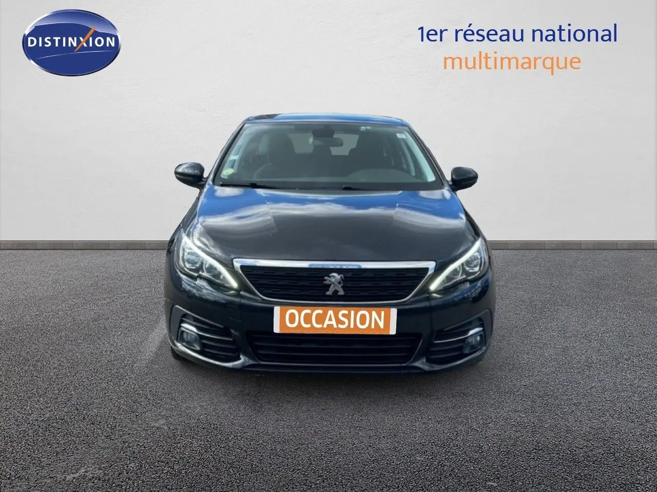 Vue frontale d'une Peugeot 308 SW noire Perla Nera Metal avec calandre chromée et phares LED allumés.